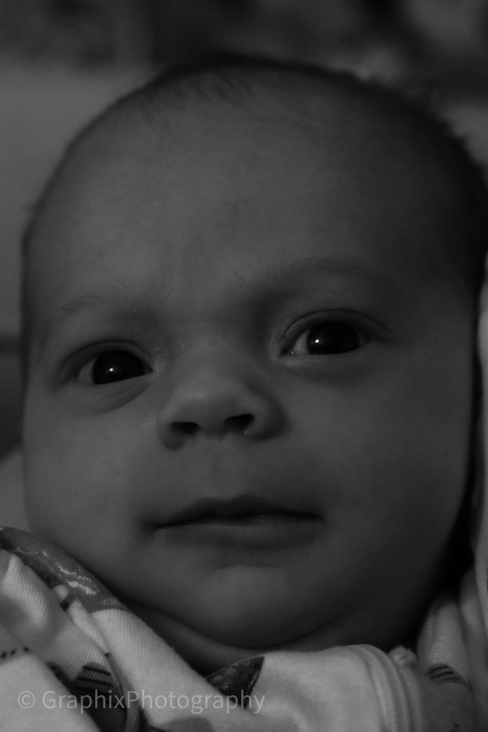 Black-and-white close portrait of an infant looking toward the camera